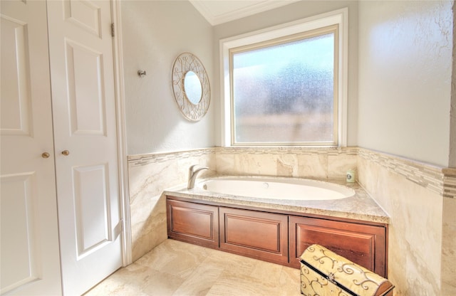 bathroom with ornamental molding, tile walls, and a tub