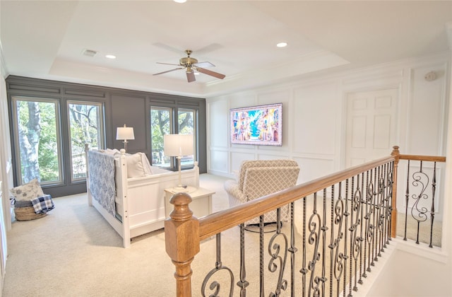 carpeted bedroom with crown molding, ceiling fan, and a tray ceiling