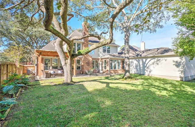 rear view of house with a patio, central AC, and a lawn