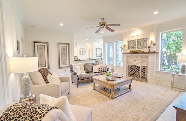 living room with ceiling fan, ornamental molding, and a fireplace