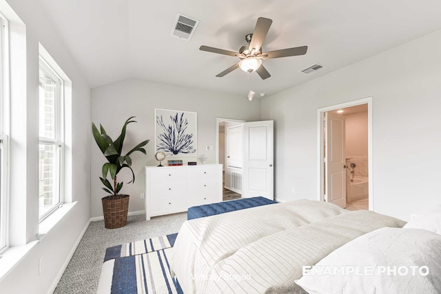 bedroom with ensuite bathroom, carpet flooring, visible vents, and baseboards