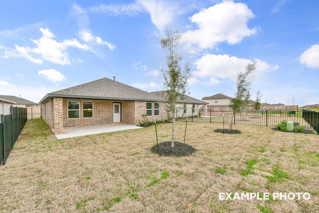 back of property with brick siding, a fenced backyard, a lawn, and a patio