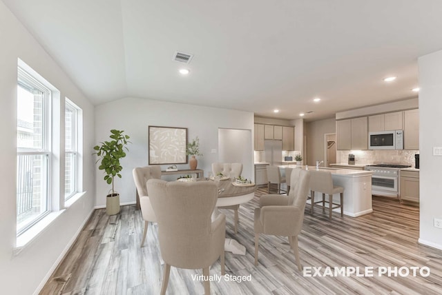 interior space with recessed lighting, visible vents, baseboards, vaulted ceiling, and light wood-type flooring