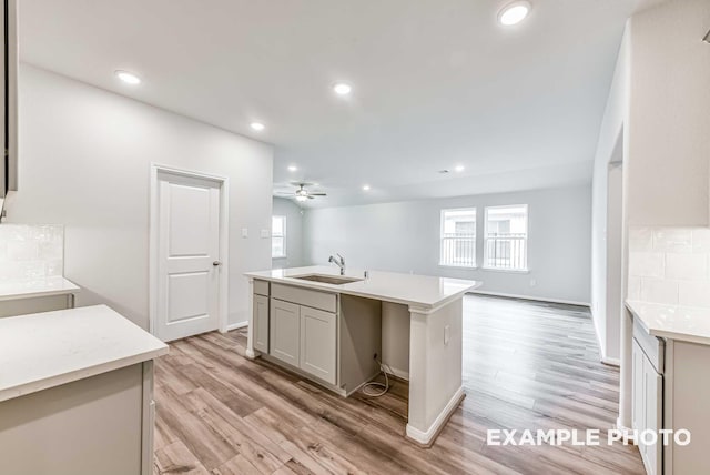 kitchen featuring a healthy amount of sunlight, backsplash, a sink, and open floor plan