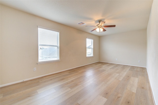 empty room with ceiling fan and light hardwood / wood-style flooring