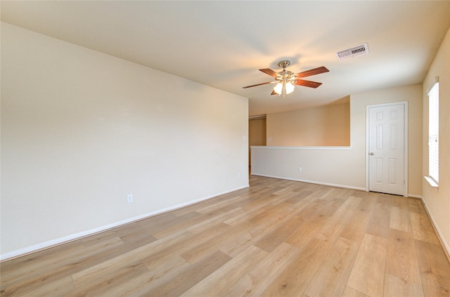 spare room featuring a healthy amount of sunlight, light hardwood / wood-style floors, and ceiling fan