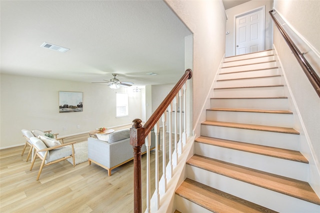 stairs with hardwood / wood-style flooring and ceiling fan