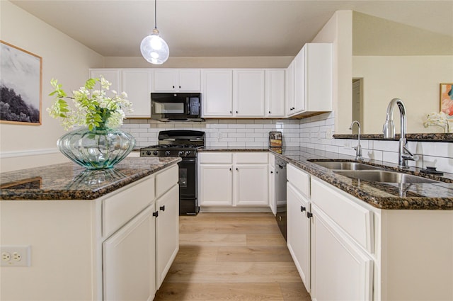 kitchen with white cabinets, dark stone countertops, sink, and black appliances