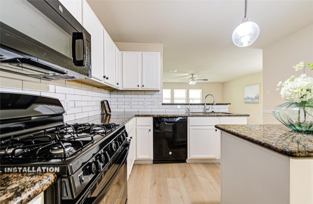 kitchen featuring hanging light fixtures, black appliances, sink, and white cabinets