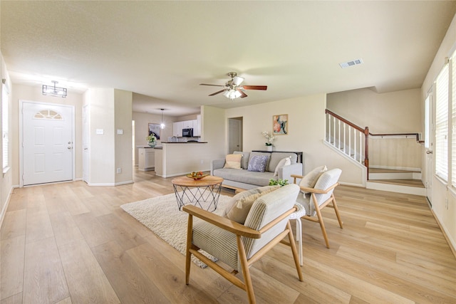 living room with ceiling fan and light wood-type flooring