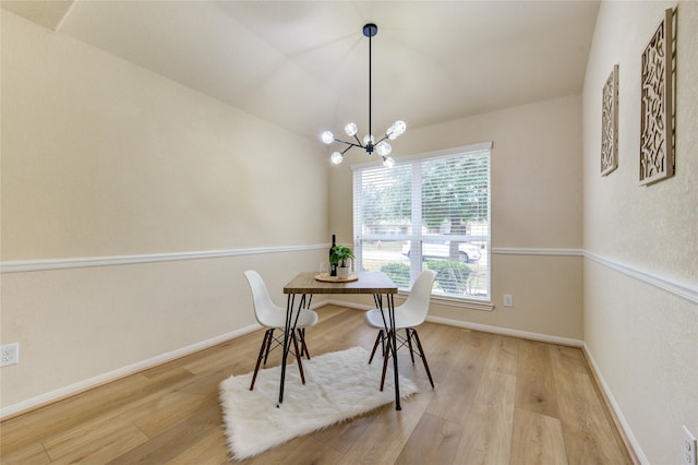 dining room featuring vaulted ceiling, light hardwood / wood-style floors, and a chandelier