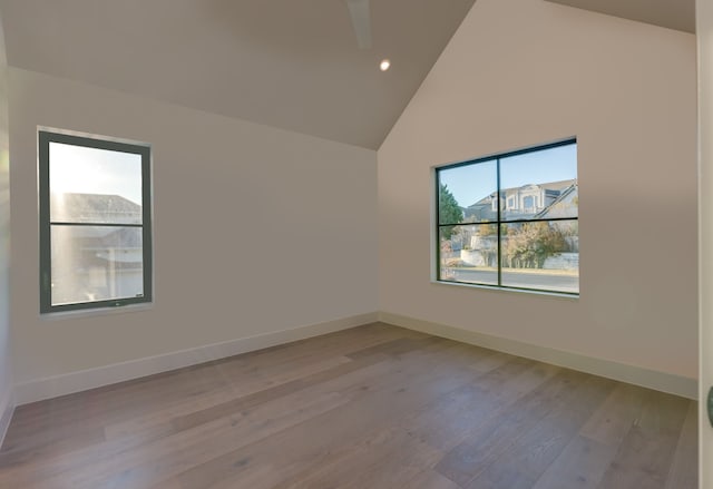 empty room with light hardwood / wood-style flooring and high vaulted ceiling