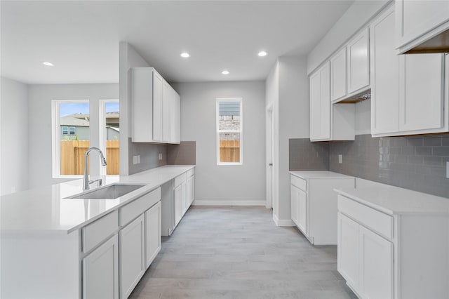 kitchen featuring white cabinetry, sink, and tasteful backsplash