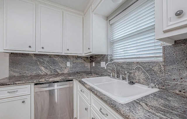 kitchen with tasteful backsplash, sink, stainless steel dishwasher, and white cabinets