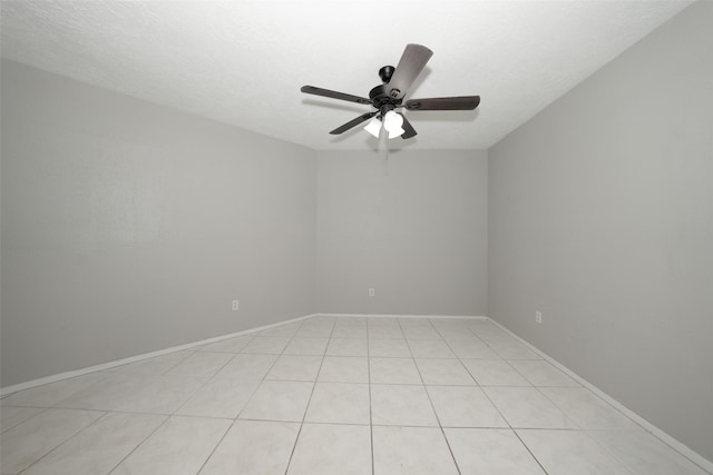 empty room featuring light tile patterned floors, a textured ceiling, and ceiling fan