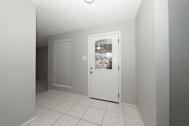 entryway featuring light tile patterned floors and a textured ceiling