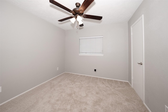 unfurnished room with ceiling fan and light carpet