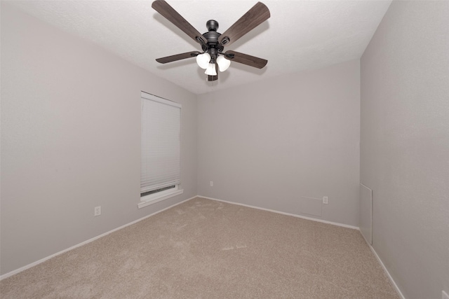 spare room with ceiling fan and carpet