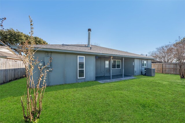 back of house featuring central AC and a lawn