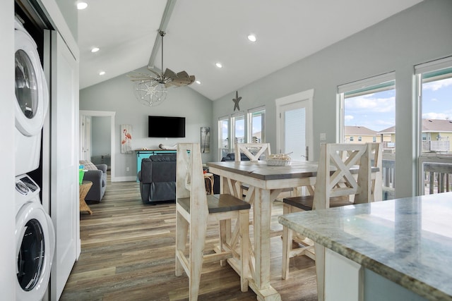 dining space featuring vaulted ceiling, recessed lighting, wood finished floors, and stacked washer / drying machine