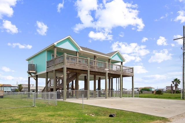 back of property with a carport, a wooden deck, and a yard