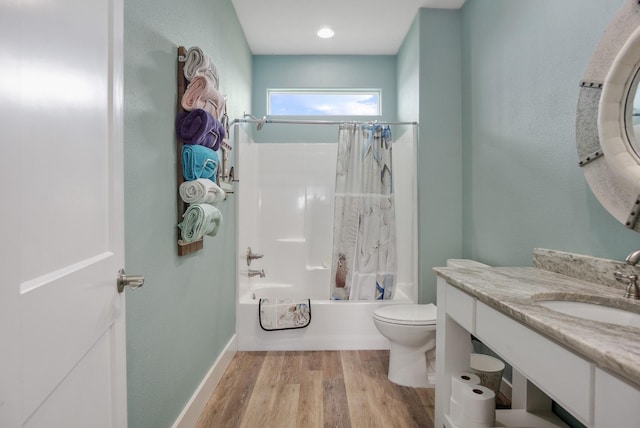 bathroom featuring baseboards, toilet, shower / bath combo with shower curtain, wood finished floors, and vanity