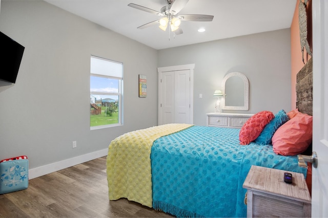 bedroom with a ceiling fan, baseboards, and wood finished floors