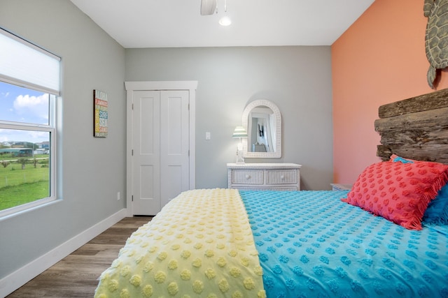 bedroom with a ceiling fan, baseboards, and wood finished floors