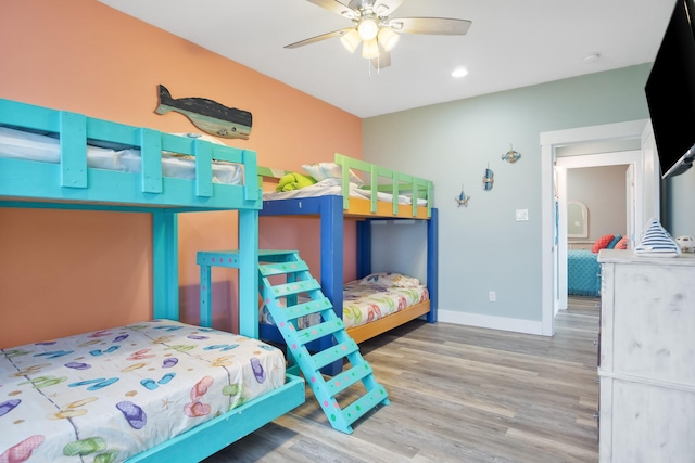 bedroom with ceiling fan, baseboards, and wood finished floors