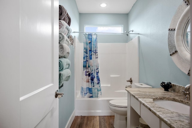bathroom with shower / bathtub combination with curtain, toilet, vanity, and wood finished floors