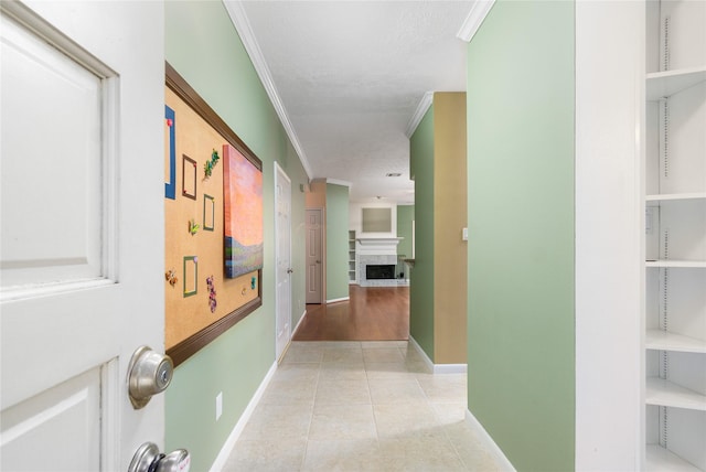 hall with light tile patterned floors, crown molding, and a textured ceiling