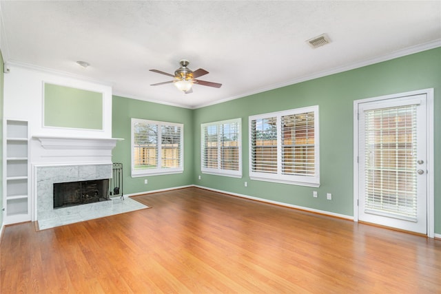 unfurnished living room with ornamental molding, a healthy amount of sunlight, and a fireplace