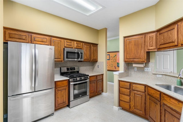 kitchen featuring stainless steel appliances, tasteful backsplash, sink, and light tile patterned floors