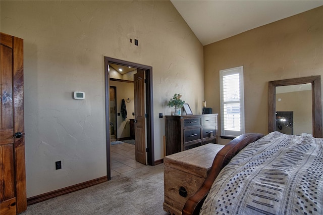 bedroom featuring light carpet, baseboards, and vaulted ceiling