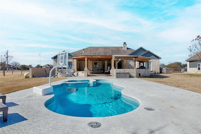 outdoor pool with outdoor dry bar, a patio area, fence, and a lawn