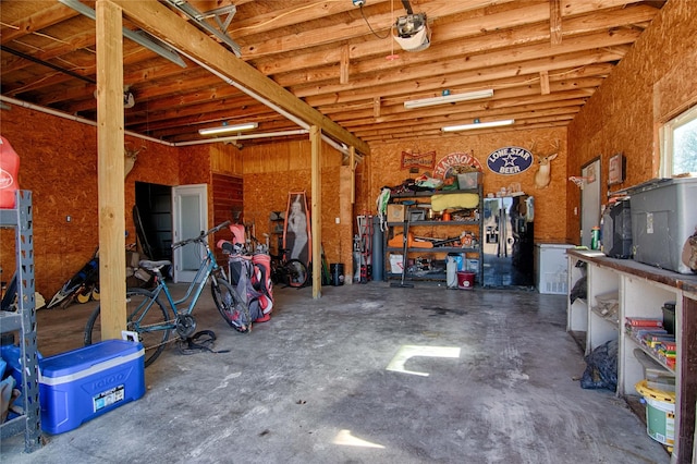 garage featuring black fridge with ice dispenser and a garage door opener