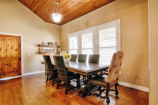 dining area featuring baseboards, wood-type flooring, vaulted ceiling, and wooden ceiling