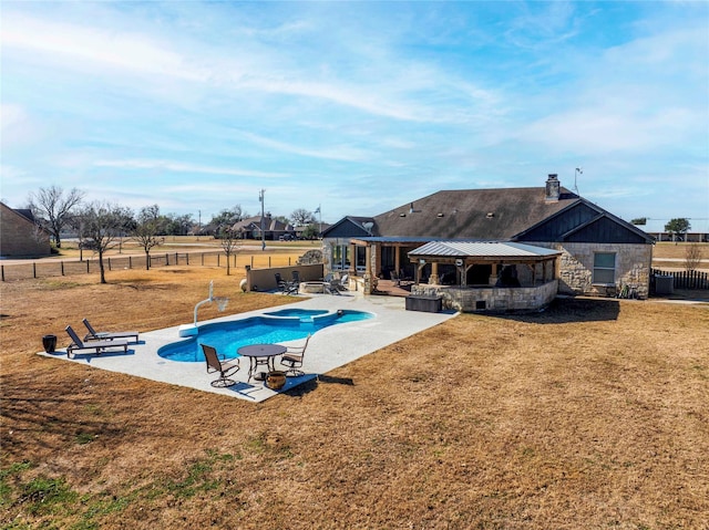 view of swimming pool with a yard, a gazebo, a pool with connected hot tub, a fenced backyard, and a patio