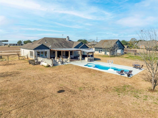 rear view of house with a fenced in pool, a patio area, a yard, and fence