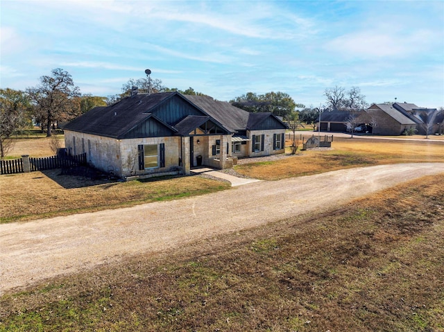 view of front of house with a detached carport, a front lawn, fence, and driveway