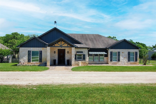 view of front facade featuring stone siding and a front lawn