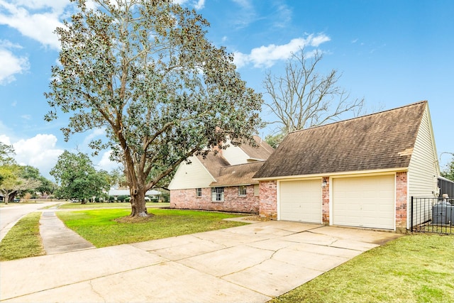 view of front of property with a garage, a front lawn, and central air condition unit