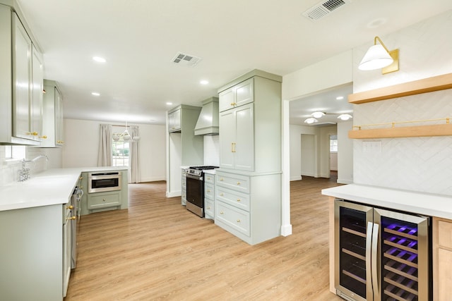 kitchen featuring sink, beverage cooler, decorative backsplash, custom exhaust hood, and gas range