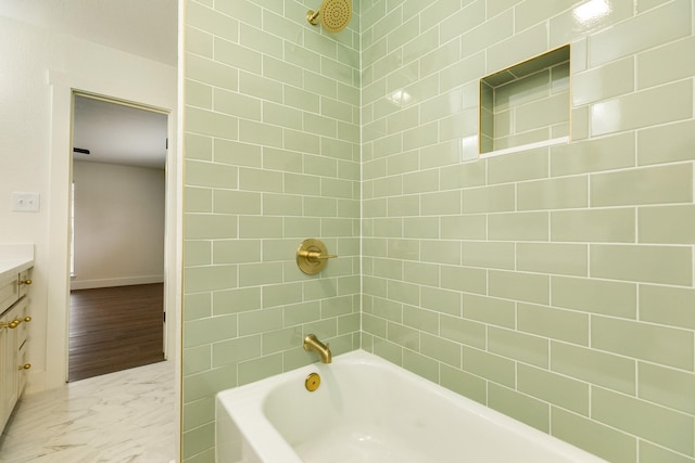 bathroom featuring vanity and tiled shower / bath