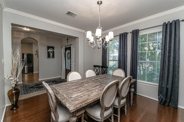 dining room with ornamental molding, dark wood-type flooring, and a chandelier