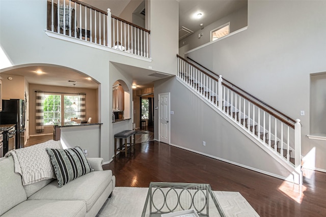 living room featuring hardwood / wood-style flooring and a towering ceiling