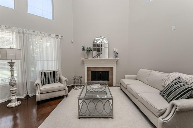 living room with hardwood / wood-style flooring, a fireplace, and a high ceiling