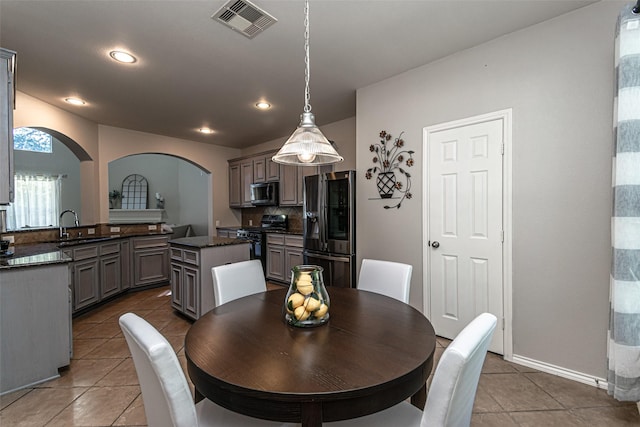 dining space featuring sink and tile patterned floors