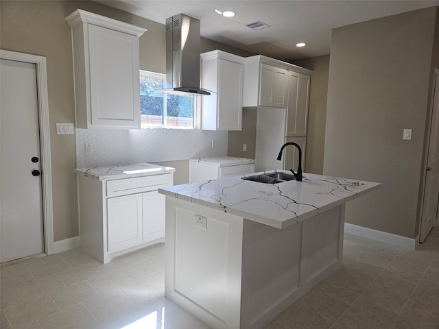 kitchen featuring white cabinetry, light stone counters, ventilation hood, and a center island with sink