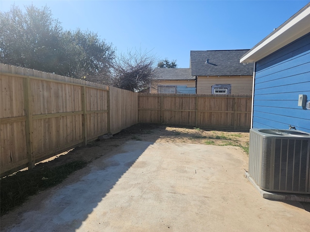 view of yard with central AC and a patio